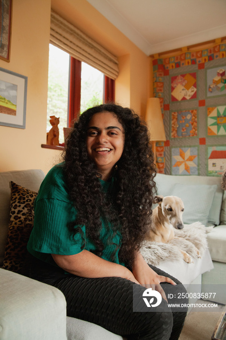 Curvy Indian girl with Cerebral Palsy playing on her phone next to her pet dog