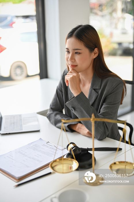 Portrait, Professional Asian female lawyer or legal advisor sitting at her office desk.