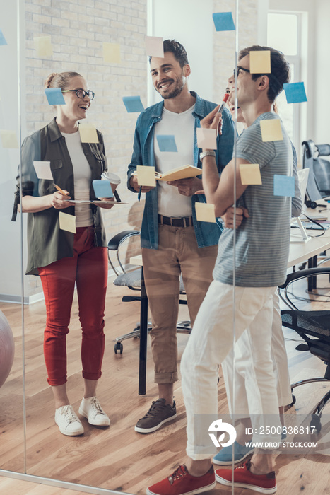 Young smiling coworkers are having discussion in meeting room