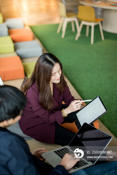 Business meeting and teamwork concept. Asian businesswoman sharing work plan to colleagues using digital tablet for presentation at workplace. Coworkers team brainstorming ideas in office