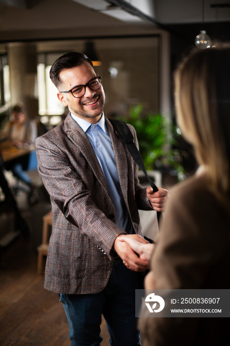 Businesswoman and businessman discussing work in office. Businessman and businesswoman handshake