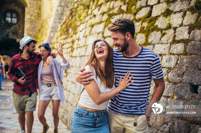 Young millennials friends walking in city old town center on summer vacation