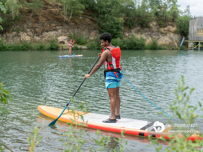 Friends paddleboarding on lake