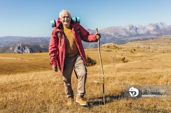 Senior man on hike through beautiful countryside in autumn.