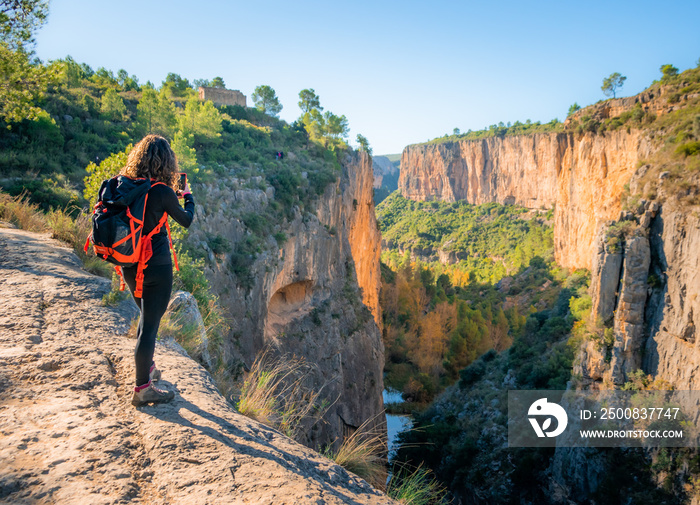 Joven mujer fotografiando el inmenso cañón  del río Turia a su paso por Chulilla (València)