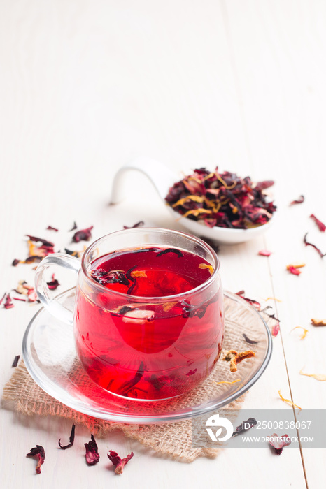 Cup of fresh red tea on white wooden background