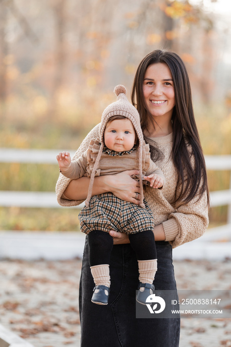 Young beautiful mother playing with her daughter in autumn park on sunny day. mother’s day