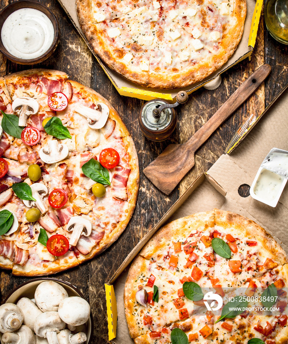 variety of pizzas with mushrooms and sauce.