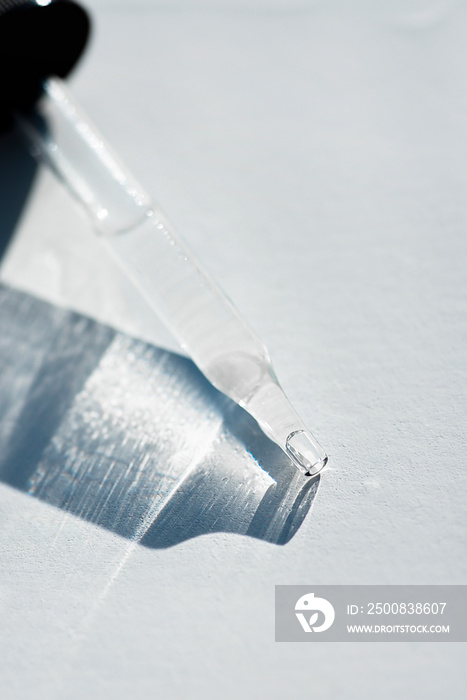 Pipette close-up on a light background in soft focus. Beautiful shadow in the sunlight. Skincare products , natural cosmetic. Beauty concept for face and body care