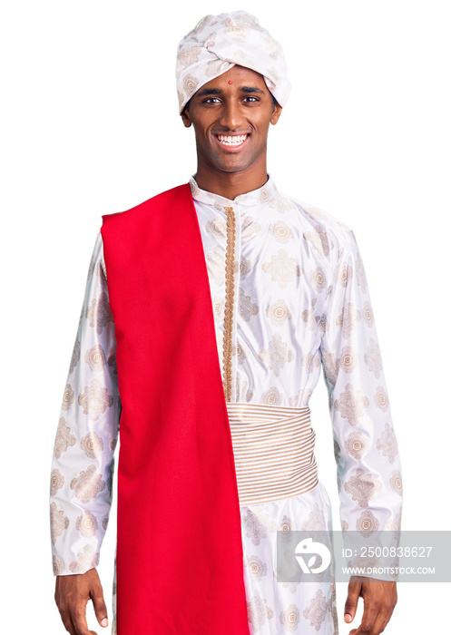 African handsome man wearing tradition sherwani saree clothes with a happy and cool smile on face. lucky person.