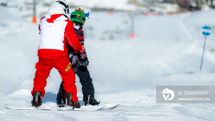 Boy Learning Snowboarding with an Instructor