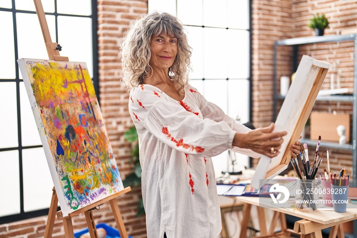 Middle age woman artist looking draw at art studio