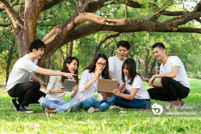 Team of young students studying in a group project in the park of university or school. Happy learning, community teamwork and youth friendship concept.