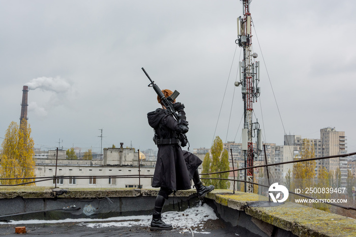 Young woman in modern black techwear style with rifle posing on the rooftop, portrait of redhead woman cyperpunk or   post apocalyptic concept