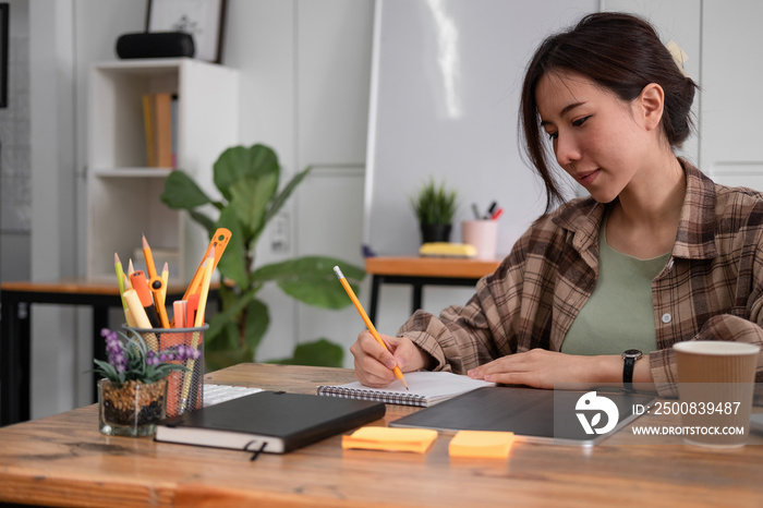 Cropped photo of woman writing making list taking notes in notepad working or learning on laptop indoors- educational course or training, seminar, education online concept