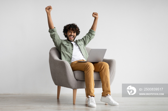 Emotional hindu guy with laptop celebrating success