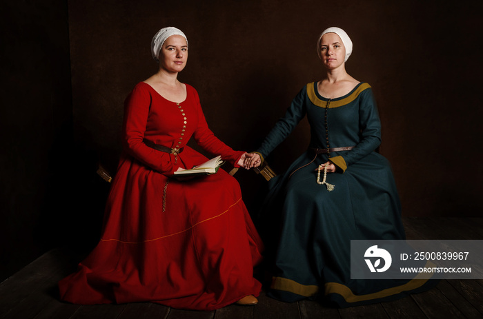 Two sisters (twins) in medieval costumes play the nobility. Evening reading of the prayer (bible).