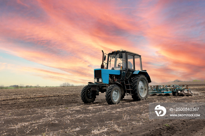 Farmer in tractor preparing farmland with seedbed