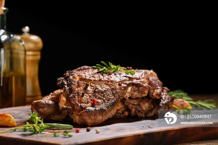 Cooked juicy steak meat beef with seasoning on wooden chopping board.