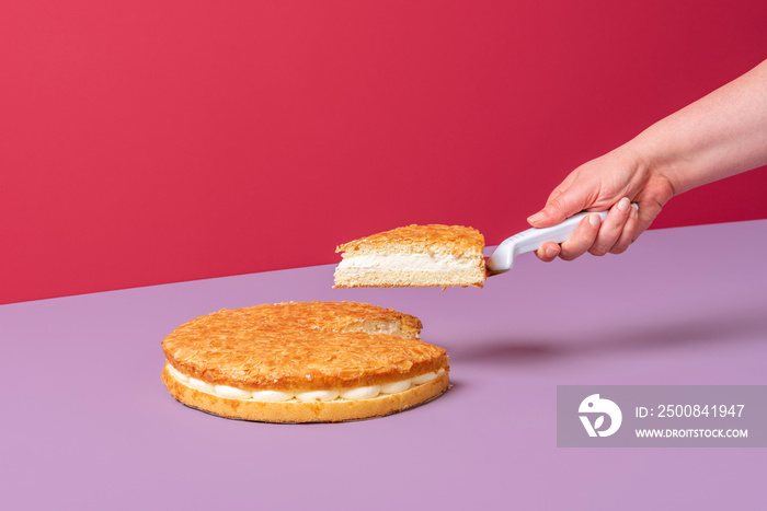 Almond cake minimalist on pink background. Woman taking a slice of cake.