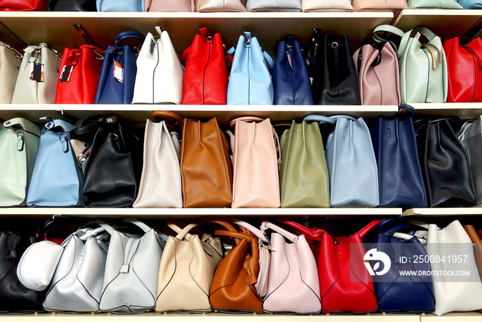 Collection of multi-colored women’s handbags on the store shelfs