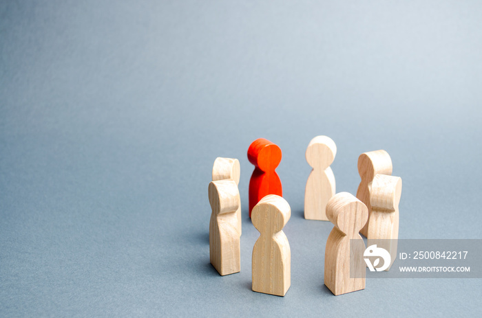 People stand in a circle on a gray background. Communication. Business team, teamwork, team spirit. Wooden figures of people. A circle of people. discussion, cooperation, cooperation. Selective focus