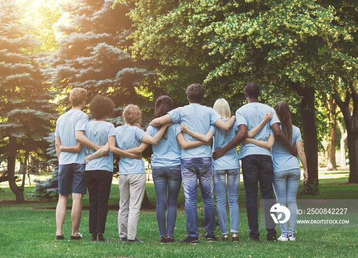 Group of happy volunteers embracing in park