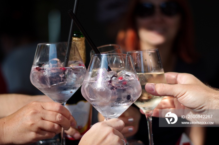 Closeup of cocktail in elegant glasses - group of people toasting