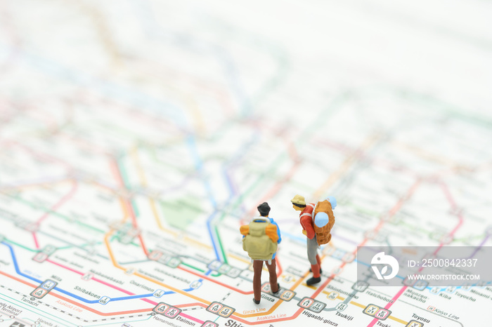 Miniature 2 people stand on a map of the subway lines in Japan. as background travel concept with copy space.