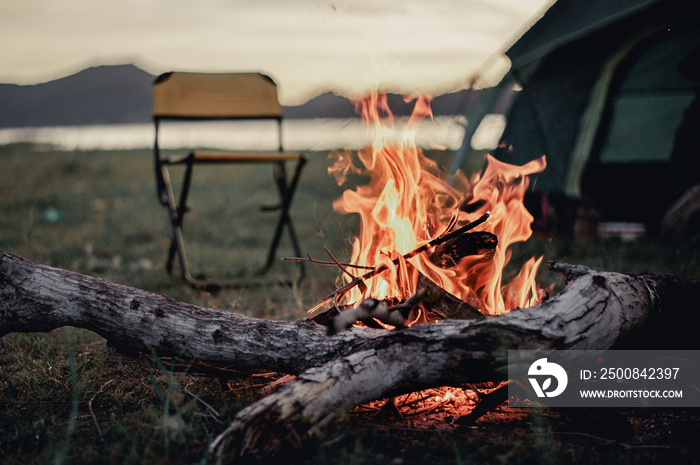 Group of friends camping.They are sitting around fire camp.