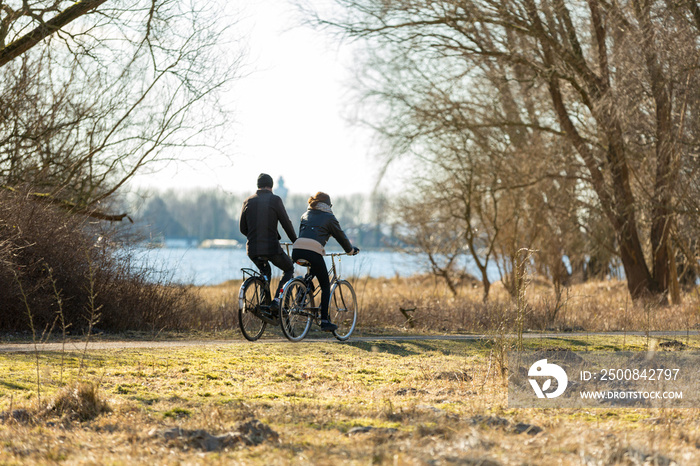 Couple biking in park   de Oeverlanden  aan de Nieuwe Meer in Amsterdam, the Netherlands.