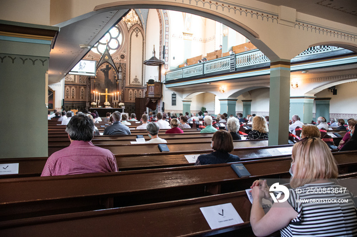 Holy mass in Christian church during the coronavirus pandemic Covid-19. Safe personal distance with protective masks