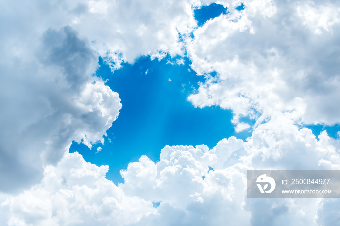 Looking up at Big white cloud and light ray behind cloud with bl