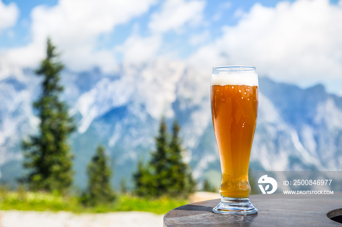 Beer. Cold golden draft beer in glass over alps. Tasty beer and tourist season in the mountains or the Alps