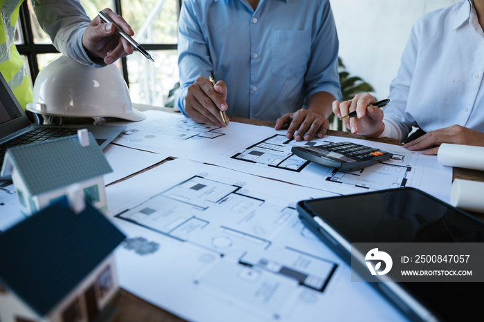 Close up of hands working calculate and brainstorming on paperworks and floor plan drawings about design architectural and engineering for houses and buildings.