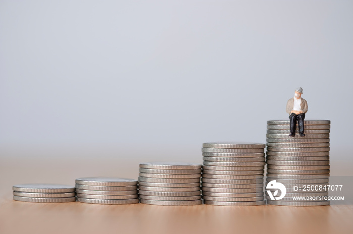 Aging society And saving money for retirement concept ,Old man sitting on coins stacking.