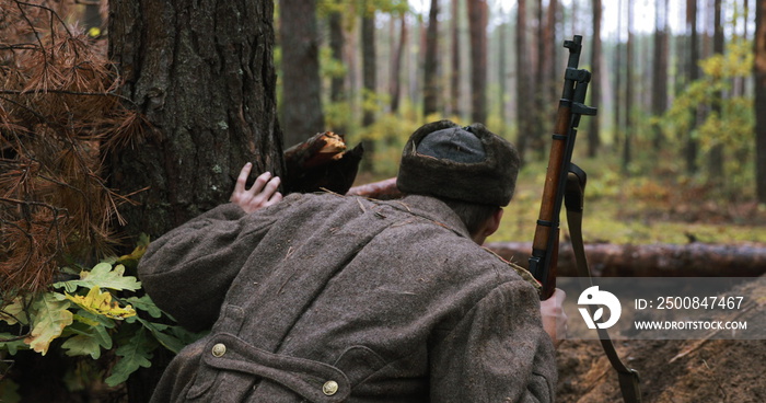 Hidden Re-enactor Dressed Like Russian Soviet Infantry Red Army Soldier In World War II Sitting In Trench Entrenchment Ambush In Autumn Forest. Historical Re-enactment. 4K