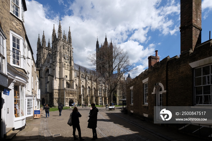 Canterbury Cathedral seen from entrance in early spring with people in foreground and houses in Canterbury, United Kingdom