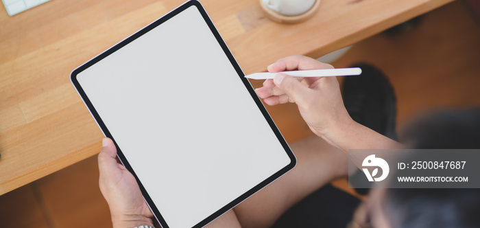 Close-up view of man working on his project with blank screen tablet