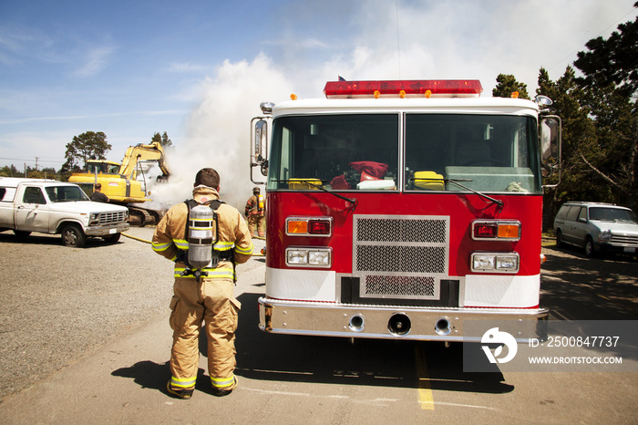 Firefighter standing by fire engine