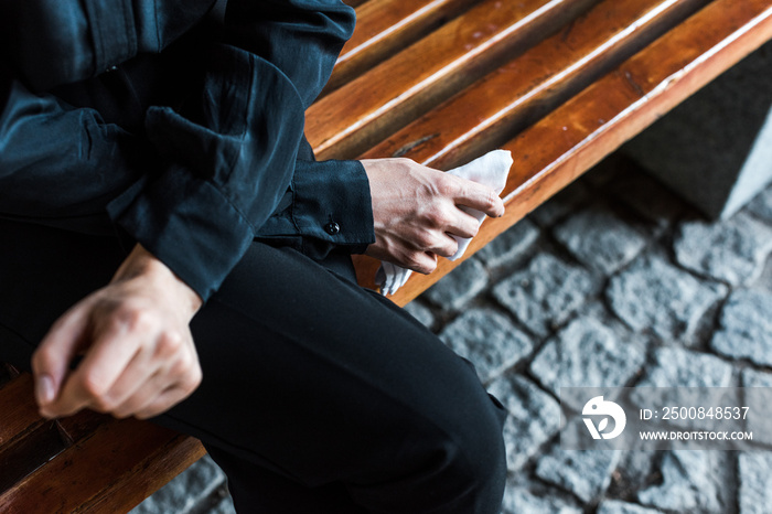 selective focus of woman holding handkerchief while sitting on bench