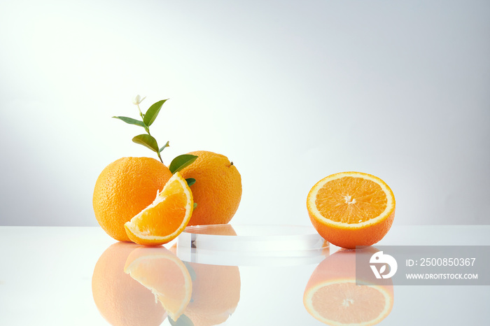 Front view of orange decorated with glassware and transparent podium in white background