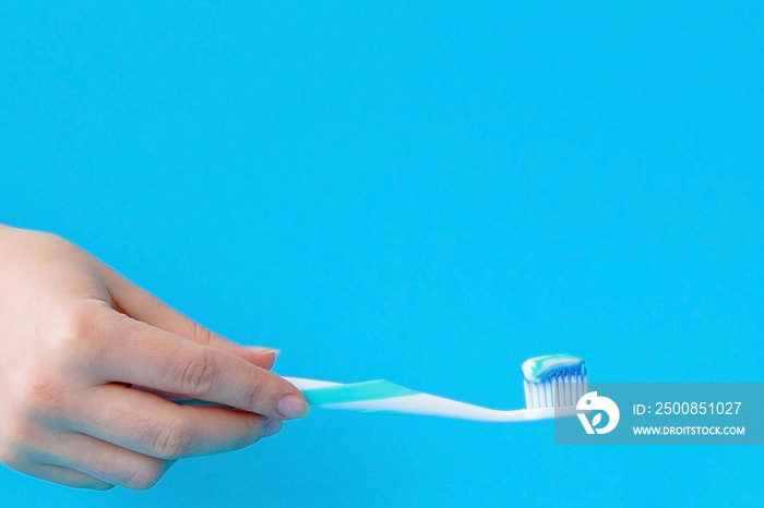 Toothpaste on a toothbrush close-up on a blue light background