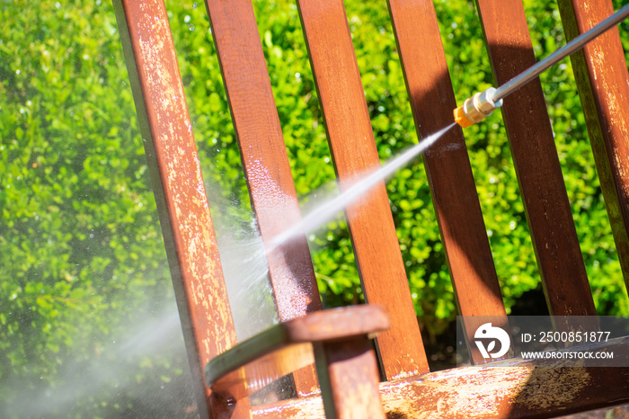 A power washer washing a chair