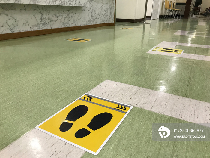 The social distancing sign stickers are on the floor of the school community to prevent the covid19 virus infection