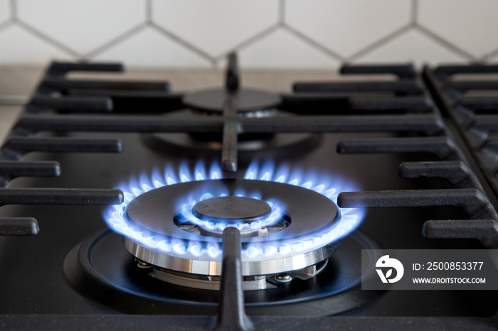 Gas burner on black modern kitchen stove. kitchen gas cooker with burning fire propane gas.