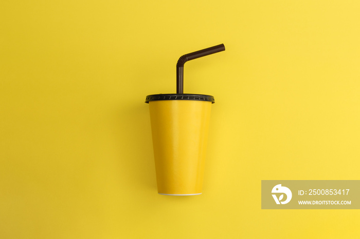 Yellow paper glass with brown lid on yellow background