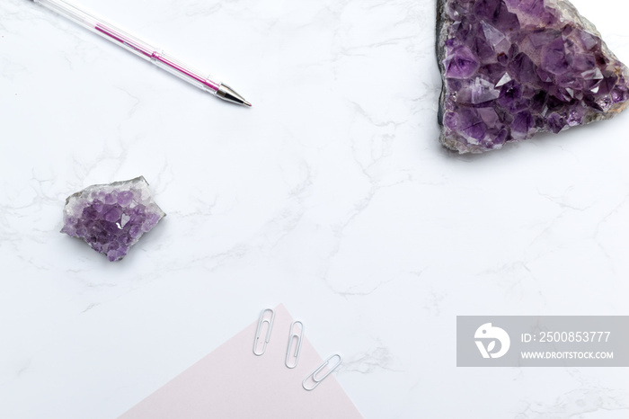 Purple themed stationary set with notebook and pen on a modern marble desk