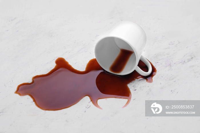 Overturned cup and spilled coffee on table