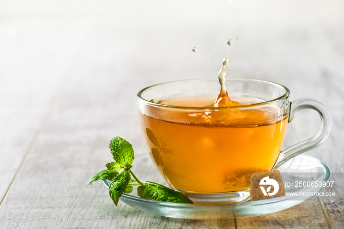 Green tea with brown sugar in clear glass. Tea splash splash from a cup.